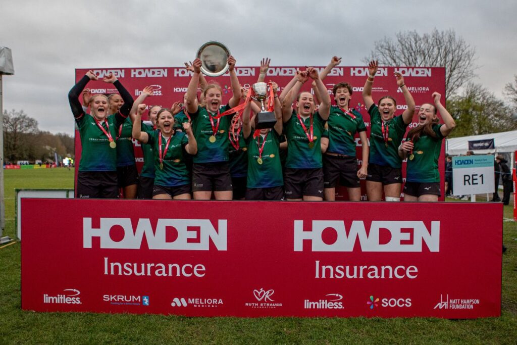 Image of victorious ARA Girls' Team at Rossyln Park 7s, holding trophy and commemorative plate and cheering.