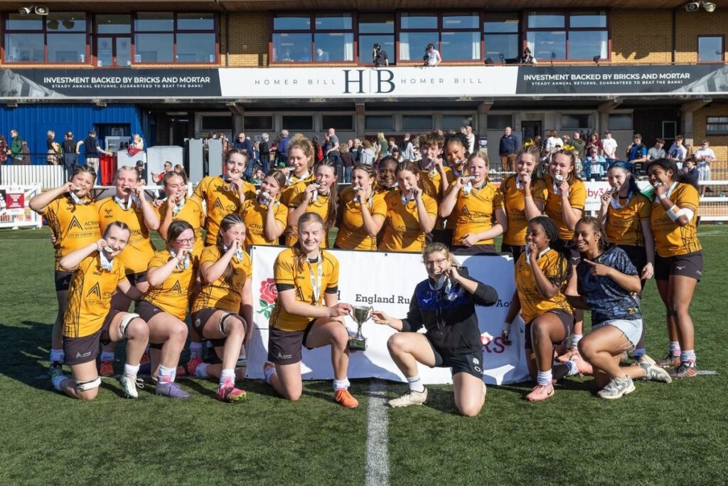 Image of Association of College's Premier Play off Final ARA Girls' team, holding their winning trophy. 